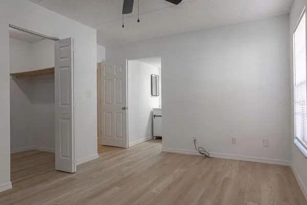 an empty room with wooden floor and mirror