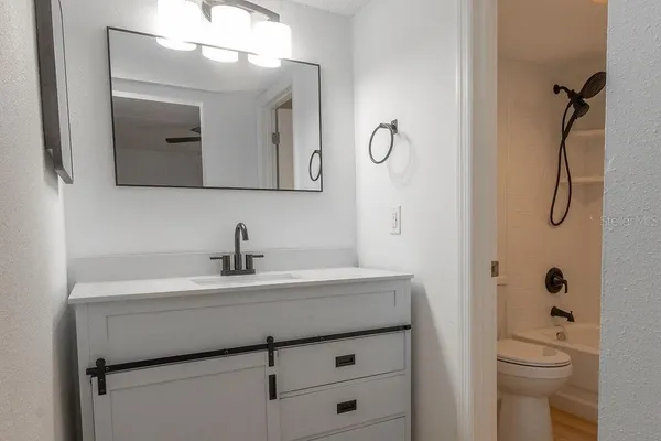 a bathroom with a sink a toilet and shower