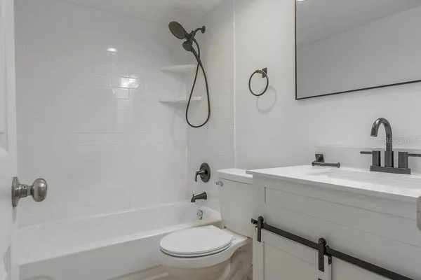 a bathroom with a sink toilet vanity and shower