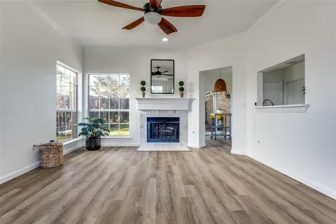 a view of an empty room with a window and fire place