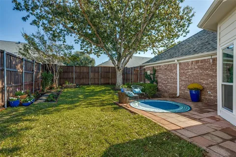 a view of a backyard with table and chairs and wooden fence