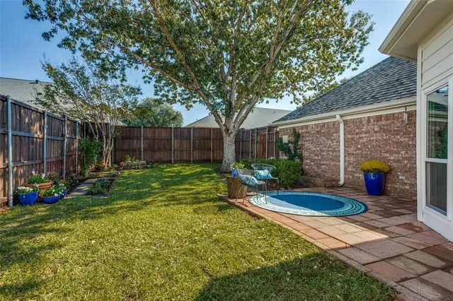 a view of a backyard with table and chairs and wooden fence