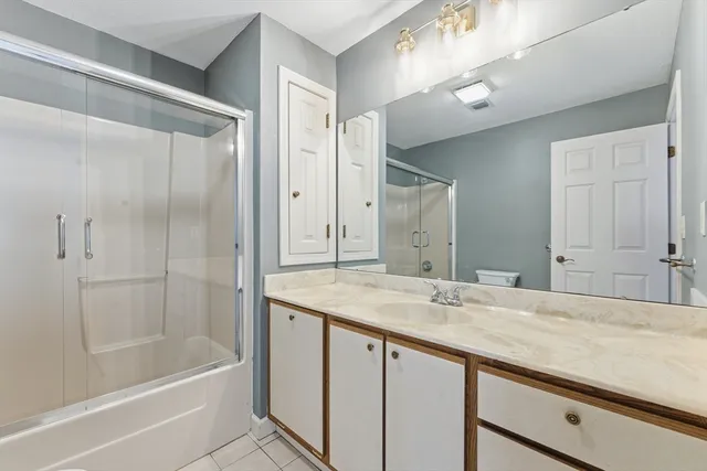 a bathroom with a granite countertop sink mirror and a bathtub