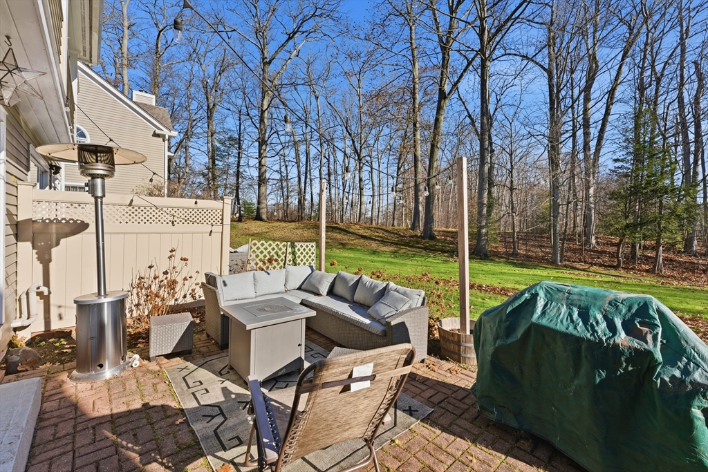 36 Shady Brook, Unit 36 West Springfield, MA 01089 - Photo 17 of 20 a view of a patio with couches table and chairs under an umbrella with large trees