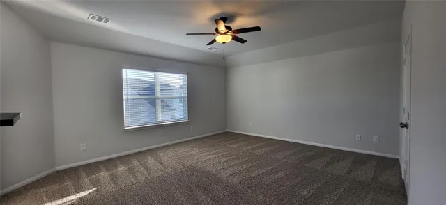 an empty room with windows and fan