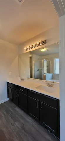a spacious bathroom with a granite countertop double vanity and a mirror