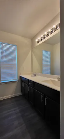 a bathroom with a double vanity sink a mirror and a window