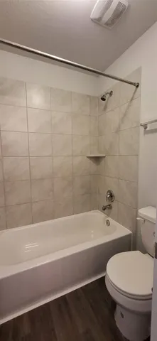 a bathroom with a toilet and a bath tub