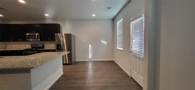 a kitchen with stainless steel appliances granite countertop a refrigerator and a sink
