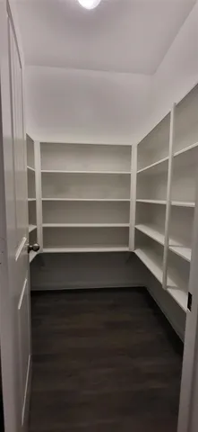 a view of walk in closet with empty racks