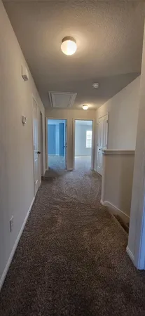 a view of a hallway with furniture and a refrigerator