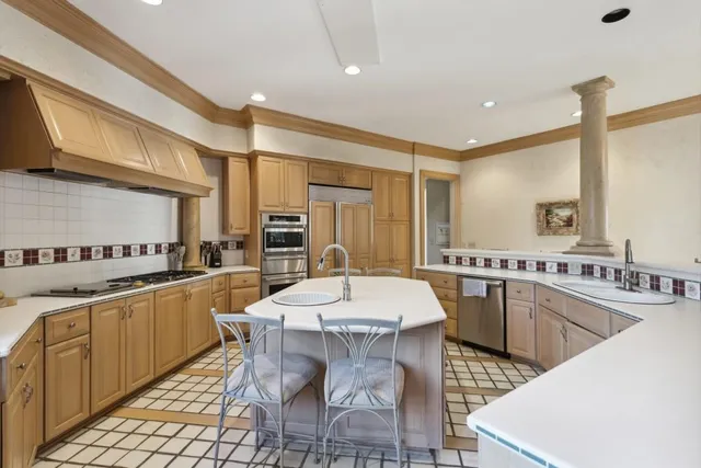 a kitchen with stainless steel appliances granite countertop a sink and a refrigerator