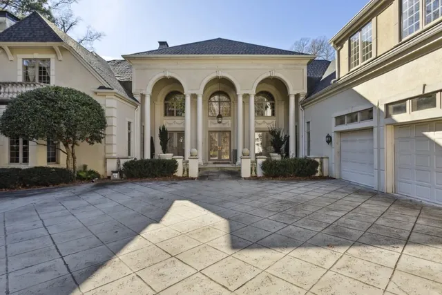a view of a grey house with large windows