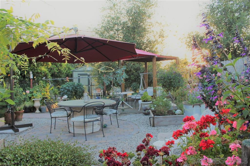 15950 Mactan Road Valley Center, CA 92082 - Photo 14 of 25 a patio with tables and chairs under an umbrella