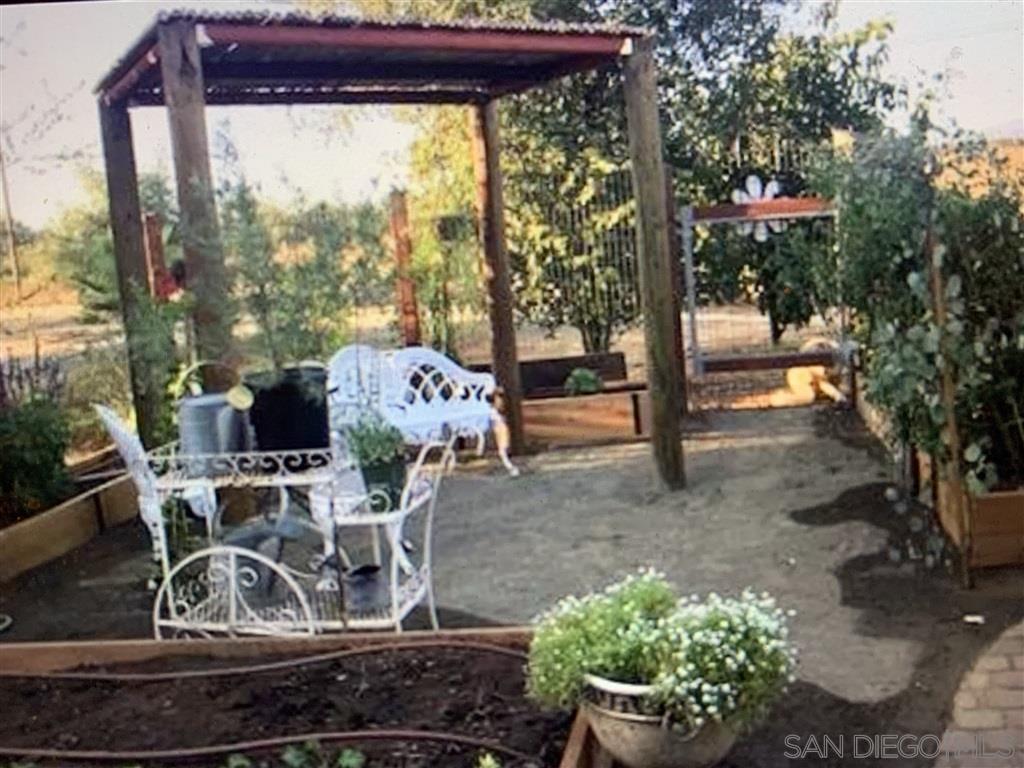 15950 Mactan Road Valley Center, CA 92082 - Photo 15 of 25 a view of a patio with table and chairs potted plants