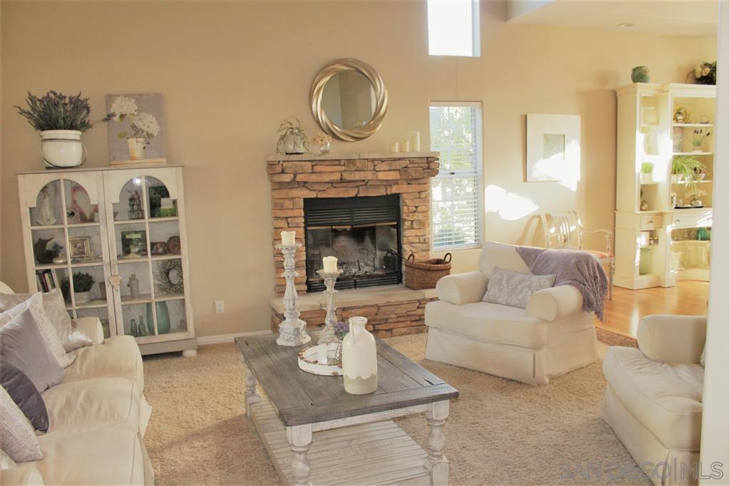 15950 Mactan Road Valley Center, CA 92082 - Photo 5 of 25 a living room with furniture a fireplace and a floor to ceiling window