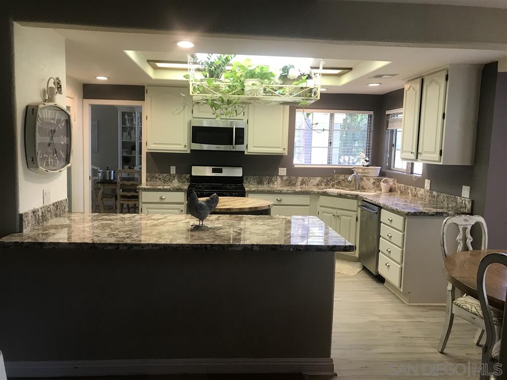 15950 Mactan Road Valley Center, CA 92082 - Photo 8 of 25 a kitchen with kitchen island granite countertop a sink a counter top space and stainless steel appliances