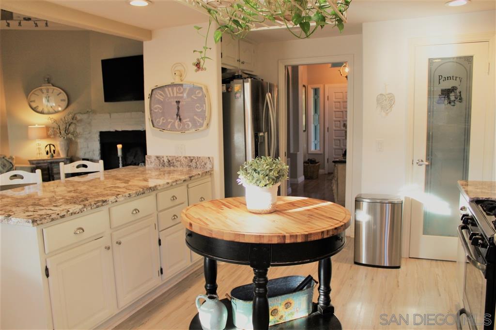 15950 Mactan Road Valley Center, CA 92082 - Photo 9 of 25 a kitchen with stainless steel appliances granite countertop a kitchen island a stove a sink and a dining table