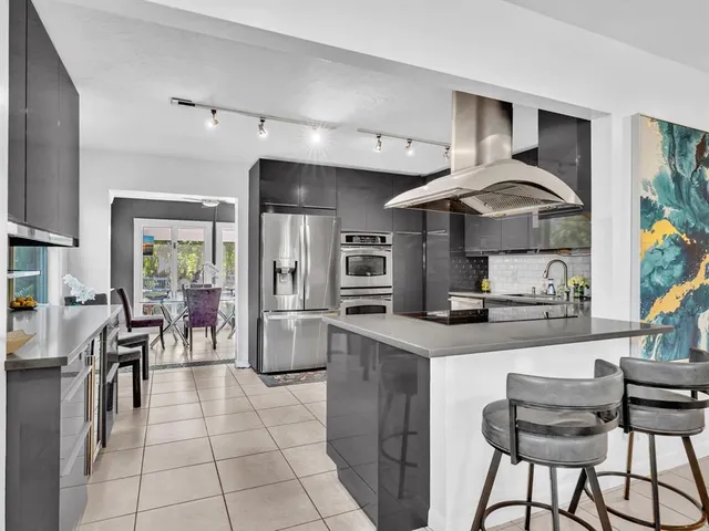 a kitchen with stainless steel appliances granite countertop a sink and a refrigerator