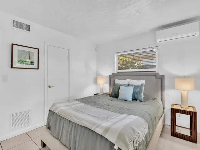 a bedroom with a bed and painting on the wall