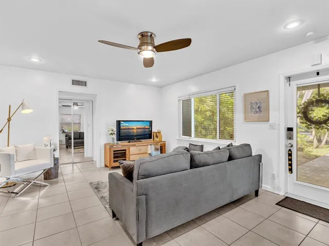 a living room with furniture and a ceiling fan