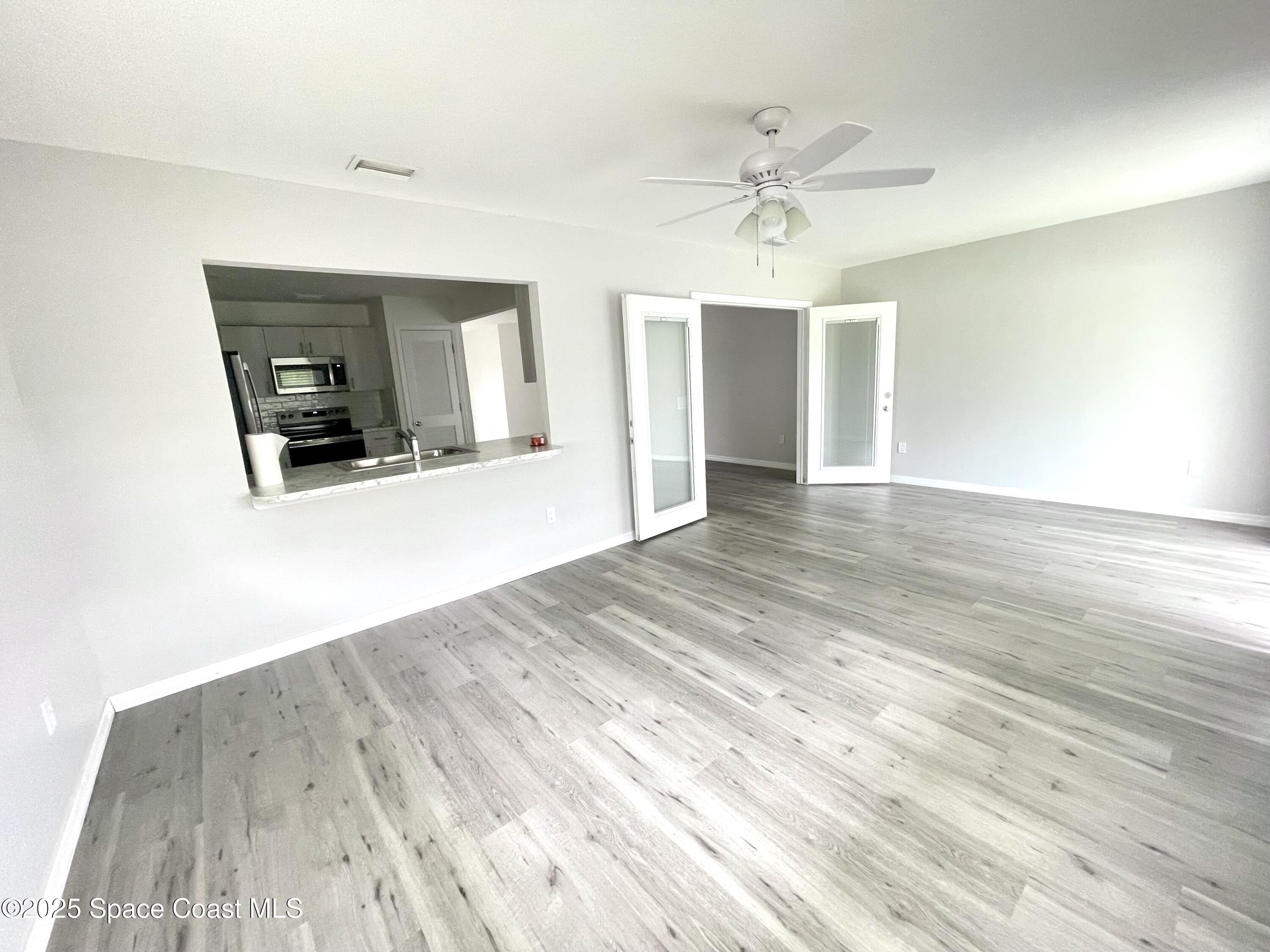 1186 Galty Circle Northeast, Unit 6 Palm Bay, FL 32905 - Photo 11 of 26 wooden floor in an empty room with a window