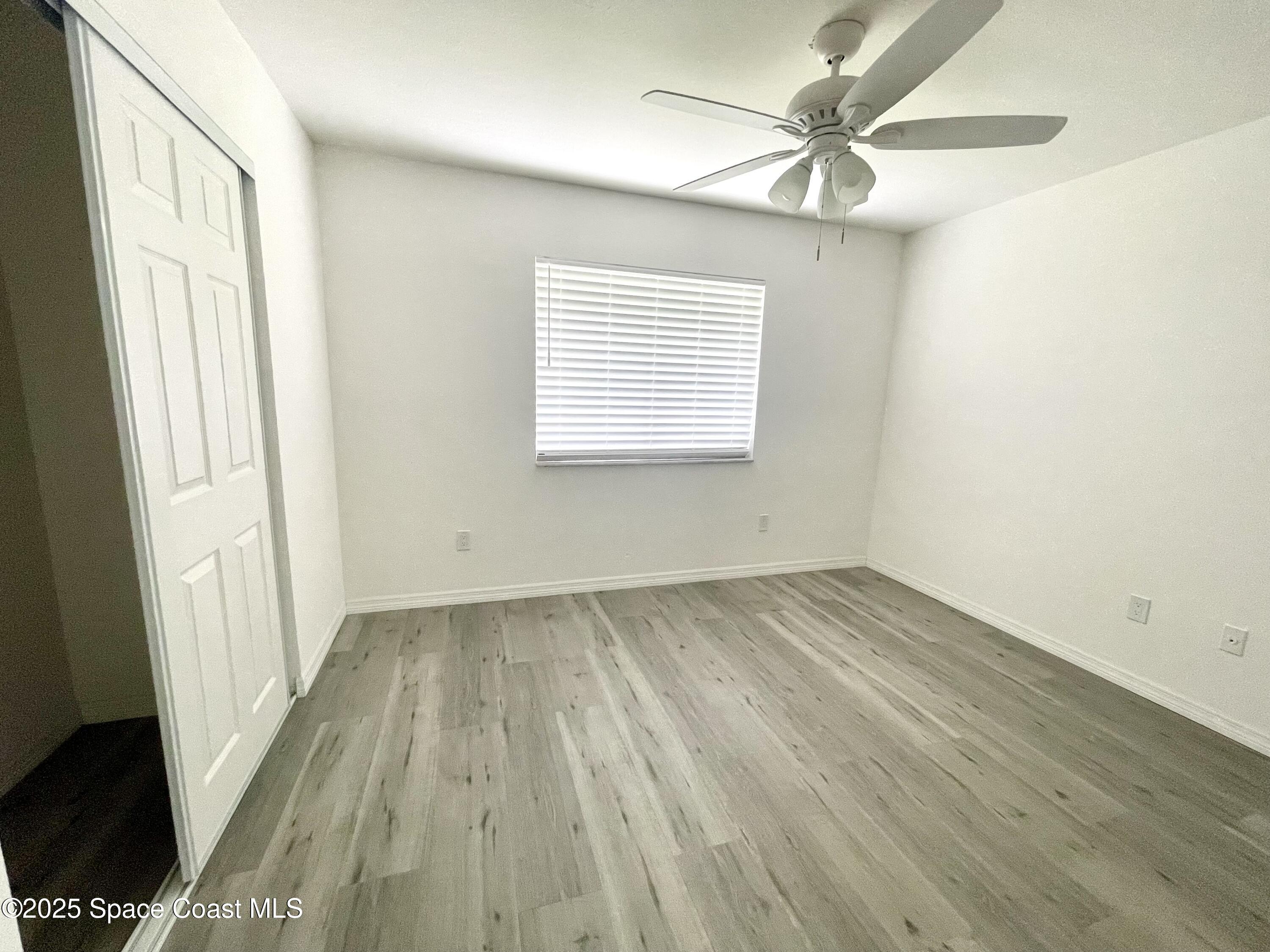 1186 Galty Circle Northeast, Unit 6 Palm Bay, FL 32905 - Photo 16 of 26 wooden floor in an empty room with a window