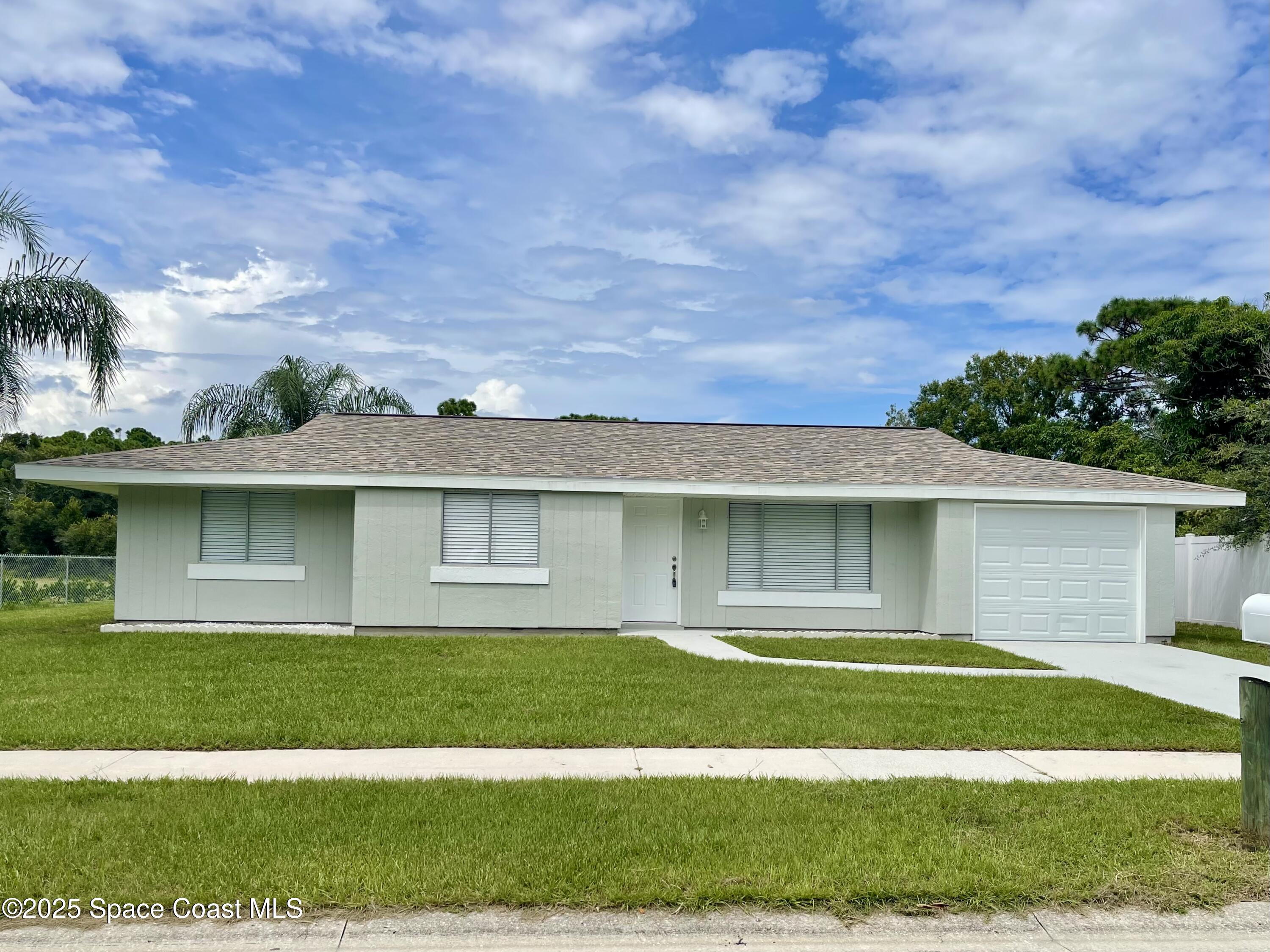1186 Galty Circle Northeast, Unit 6 Palm Bay, FL 32905 - Photo 2 of 26 a front view of a house with a garden