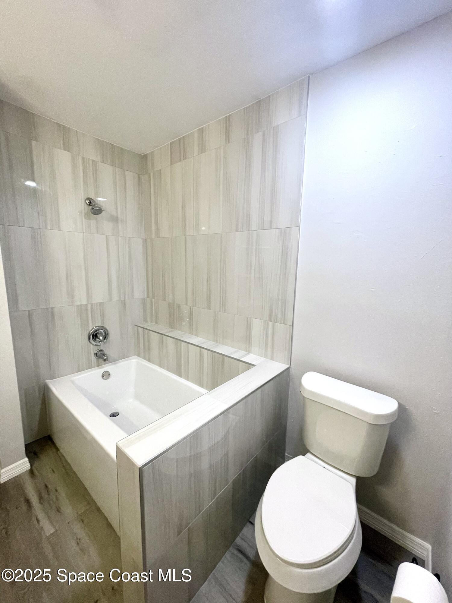 1186 Galty Circle Northeast, Unit 6 Palm Bay, FL 32905 - Photo 21 of 26 a white toilet sitting next to a bathroom sink