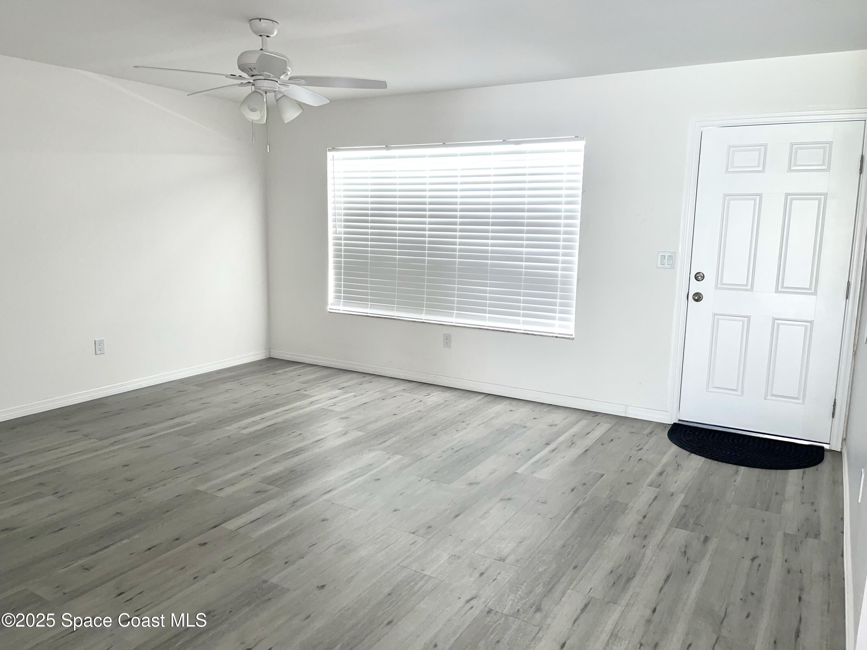 1186 Galty Circle Northeast, Unit 6 Palm Bay, FL 32905 - Photo 3 of 26 wooden floor in an empty room with a window