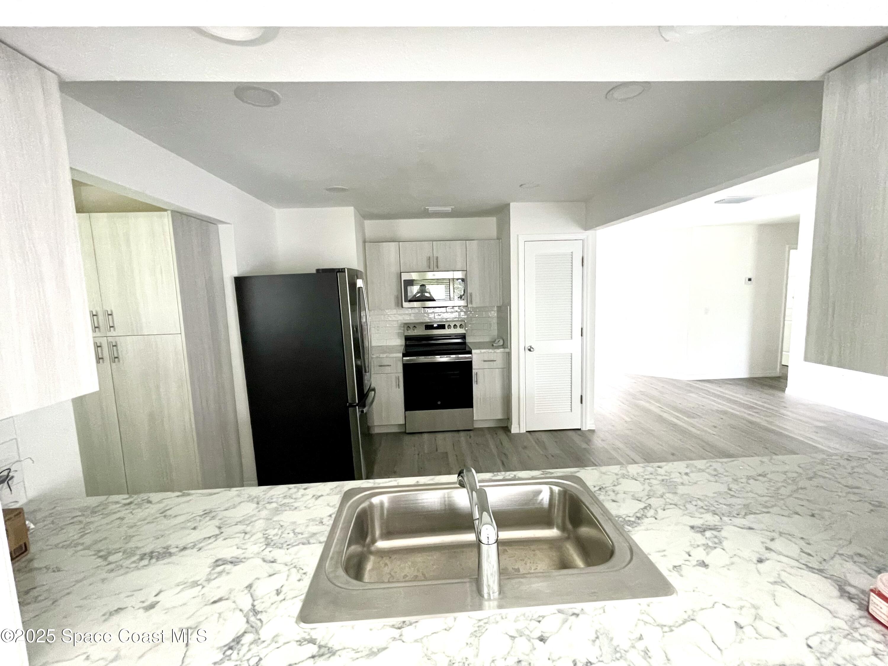 1186 Galty Circle Northeast, Unit 6 Palm Bay, FL 32905 - Photo 9 of 26 a kitchen with a refrigerator and a sink