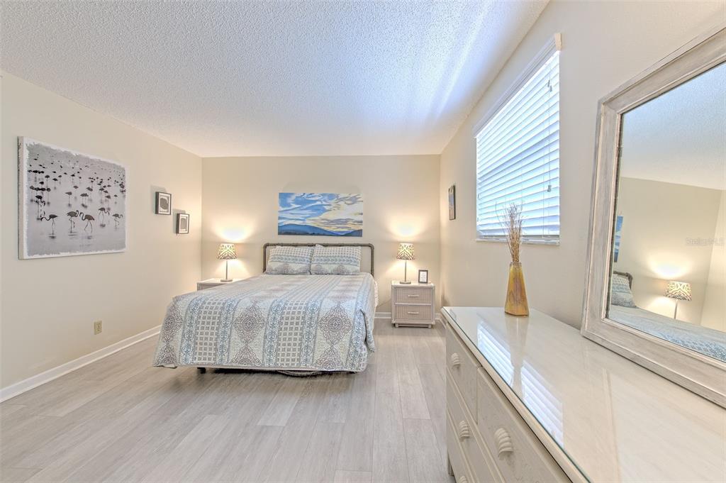 17200 Gulf Boulevard, Unit 401 North Redington Beach, FL 33708 - Photo 16 of 56 a bedroom with a bed and wooden floor