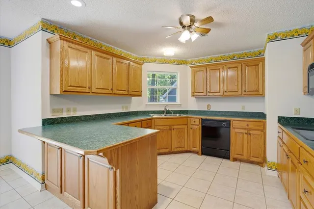 a kitchen with stainless steel appliances granite countertop a sink a stove a refrigerator cabinets and a dining table