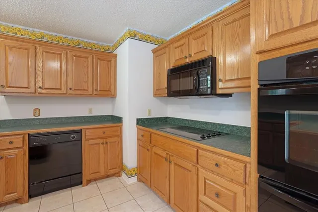 a kitchen with granite countertop cabinets stainless steel appliances and a counter space