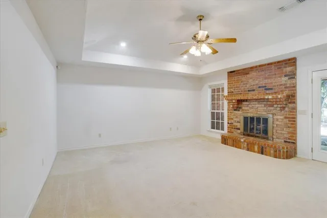 a view of an empty room with a fireplace and a window