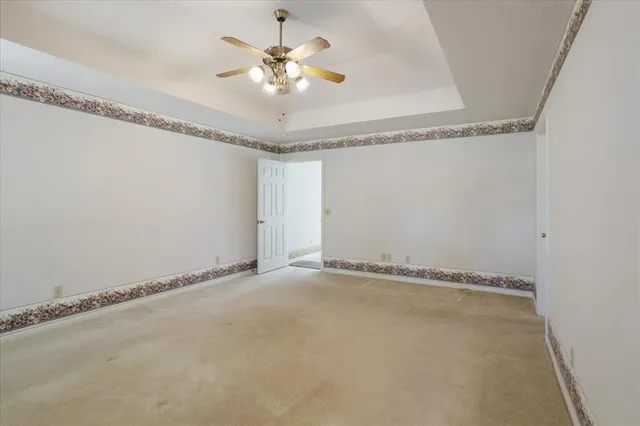 a view of a room with an empty space and a ceiling fan