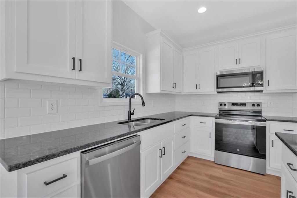 42 Dogwood Street Northeast Rome, GA 30161 - Photo 21 of 34 a kitchen with granite countertop white cabinets stainless steel appliances and a counter space