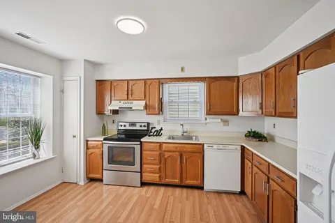 a kitchen with a sink stove and wooden cabinets