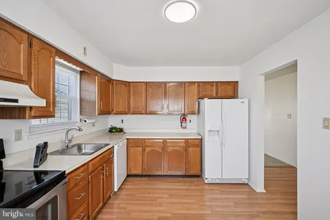 a kitchen with stainless steel appliances a refrigerator sink and wooden cabinets