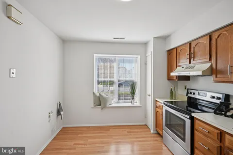 a kitchen with stainless steel appliances a stove a sink and a window