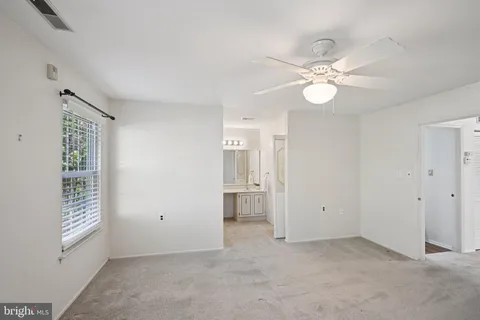 an empty room with windows and fan