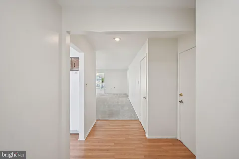 a view of a hallway with wooden floor and closet