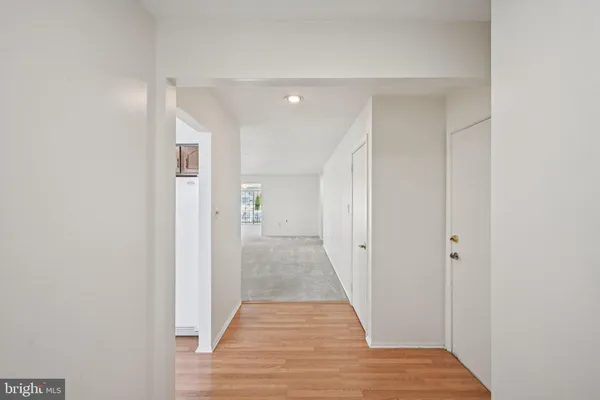 a view of a hallway with wooden floor and closet