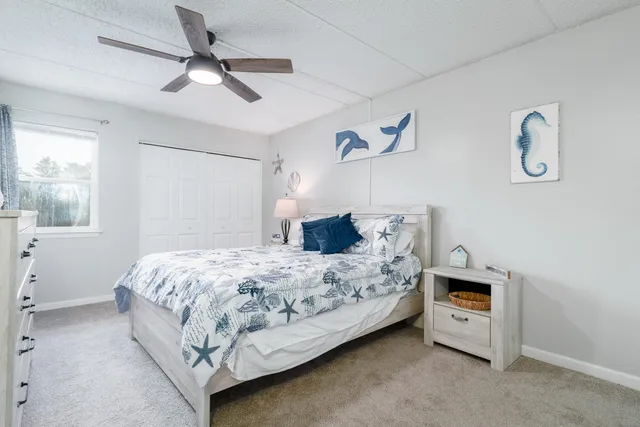 a bedroom with a bed and a ceiling fan