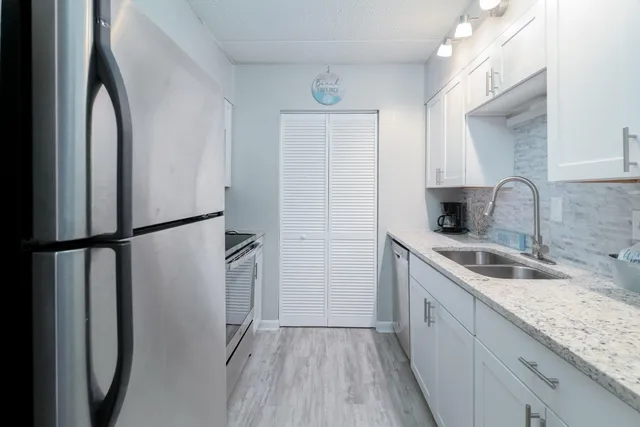 a kitchen with a sink a refrigerator freezer a washer and dryer