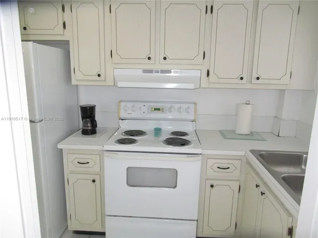 a kitchen with white cabinets and white appliances