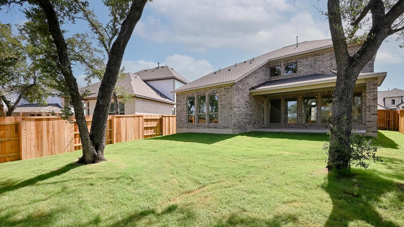 368 Prickly Poppy Loop Kyle, TX 78640 - Photo 16 of 39 Back of property featuring brick siding, a fenced backyard, and a shingled roof