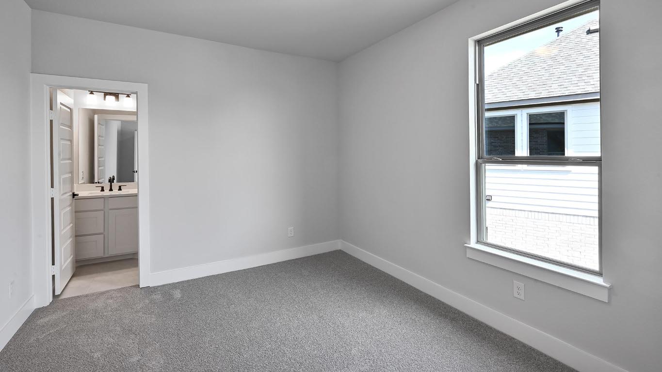 368 Prickly Poppy Loop Kyle, TX 78640 - Photo 18 of 39 Unfurnished bedroom featuring multiple windows, light carpet, and connected bathroom
