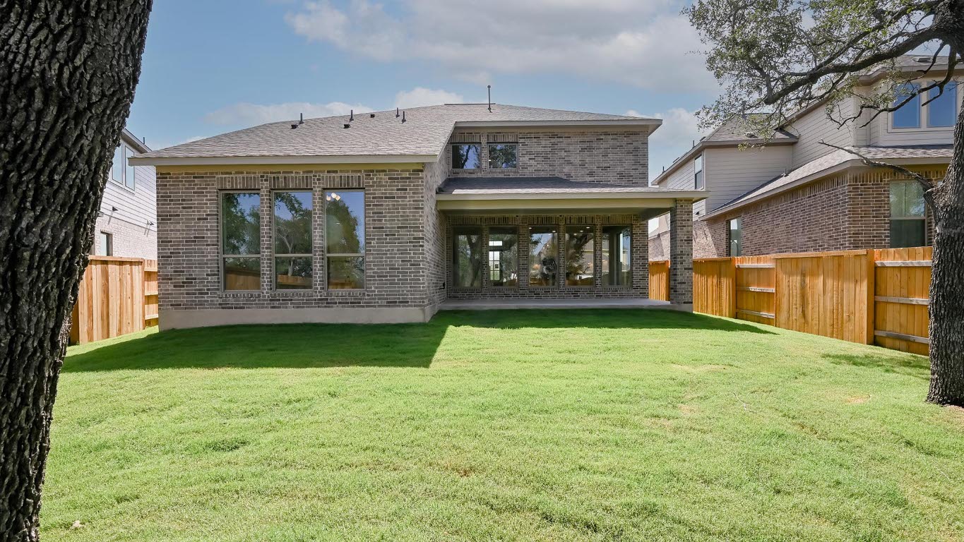 368 Prickly Poppy Loop Kyle, TX 78640 - Photo 10 of 39 Back of property featuring brick siding, a fenced backyard, and roof with shingles