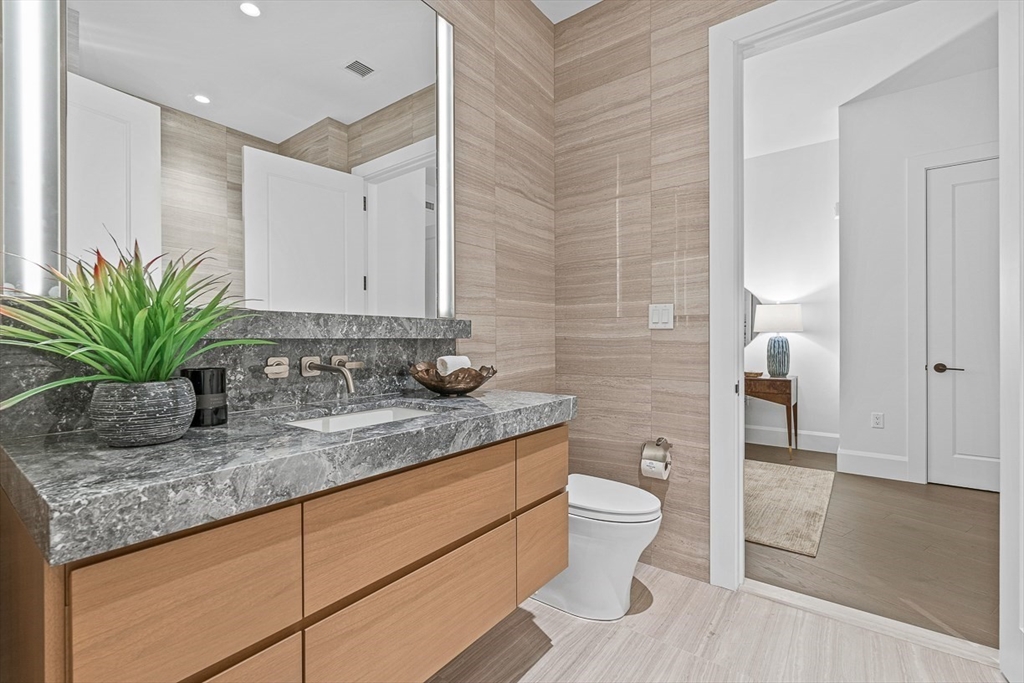40 Trinity Place, Unit PH35D Boston, MA 02116 - Photo 31 of 40 a bathroom with a granite countertop sink a toilet and a mirror